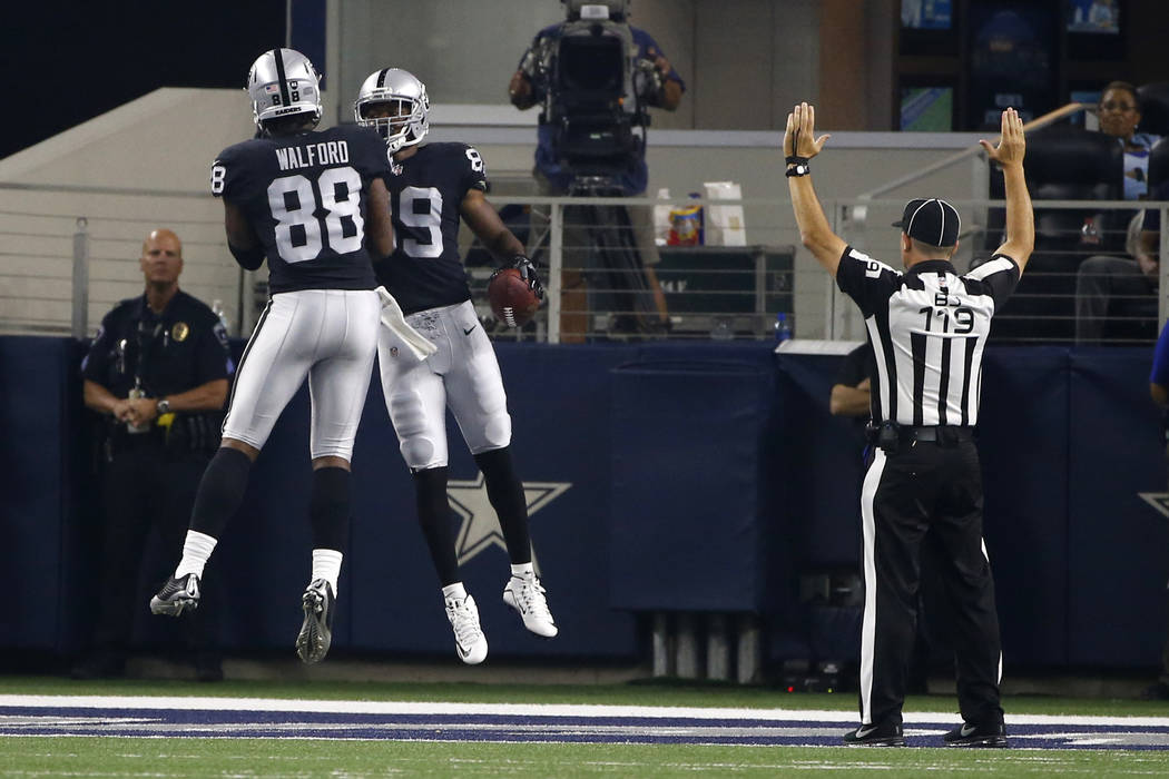 Oakland Raiders' Clive Walford (88) and Amari Cooper (89) celebrate a touchdown catch by Cooper as back judge Greg Wilson (119) signals after the play in the first half of a preseason NFL football ...
