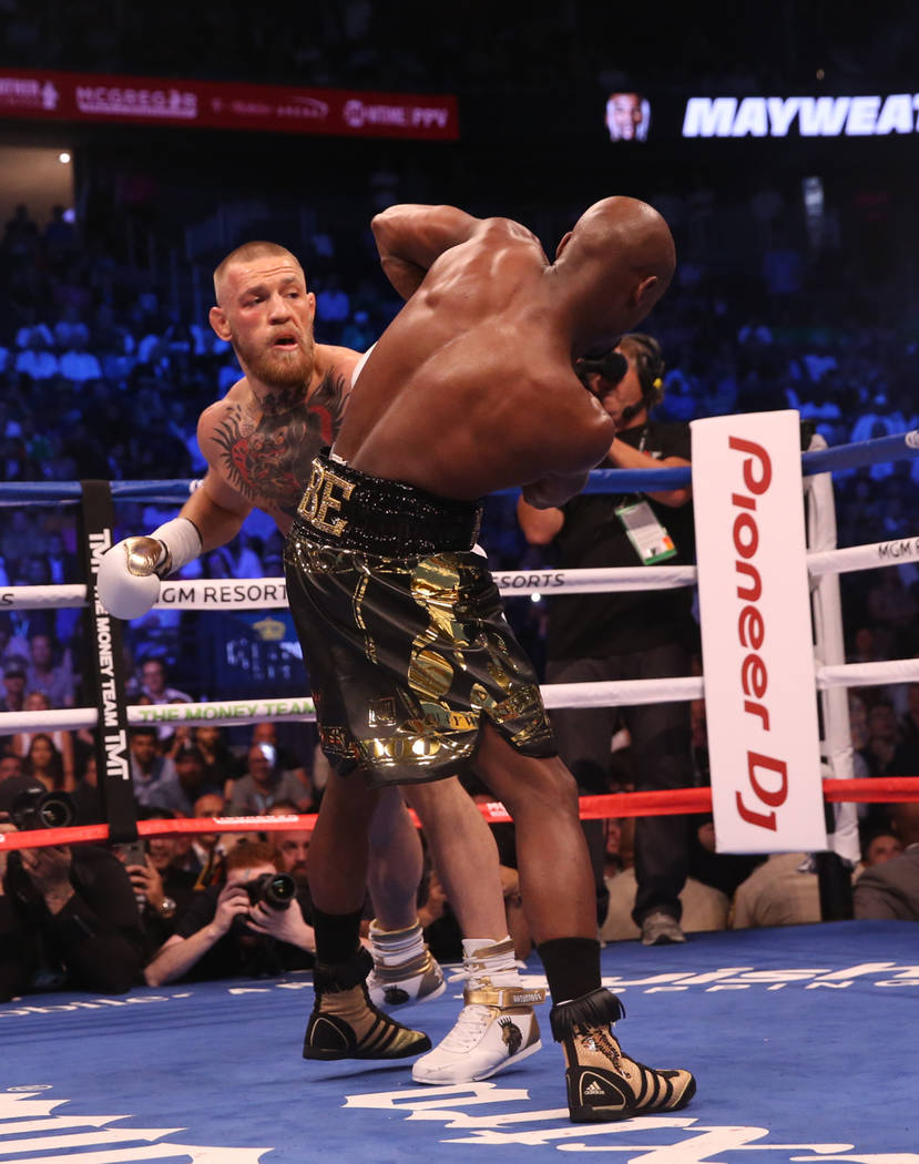 Conor McGregor, left, takes a punch at Floyd Mayweather Jr. during the first round of their fight at T-Mobile Arena, Saturday, Aug. 26, 2017, in Las Vegas. Benjamin Hager Las Vegas Review-Journal
