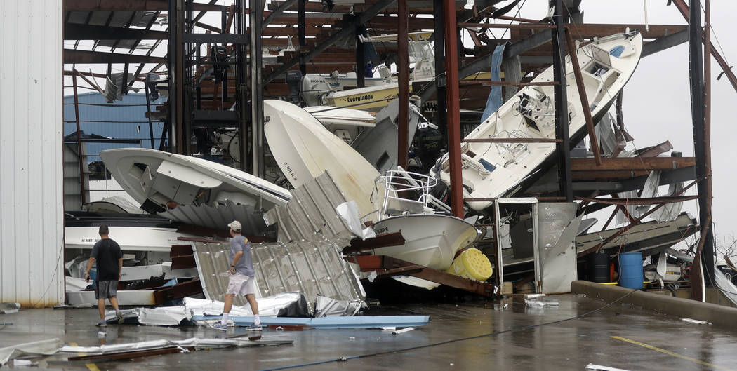 A man checks on a boat storage facility that was damaged by Hurricane Harvey, Saturday, Aug. 26, 2017, in Rockport, Texas. (AP Photo/Eric Gay)