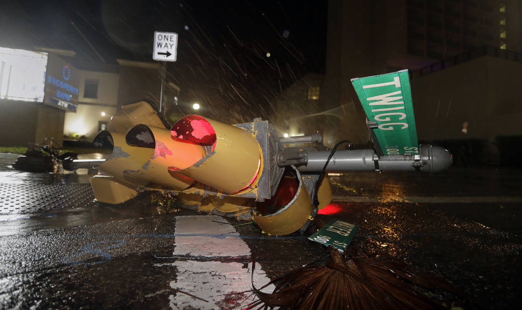 A traffic signal topped by the winds of Hurricane Harvey lies in an intersection of downtown Corpus Christi, Texas, Saturday, Aug. 26, 2017. Harvey has been further downgraded to a Category 1 hur ...