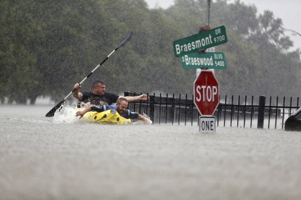 Two kayakers try to beat the current pushing them down an overflowing Brays Bayou along S. Braeswood in Houston, Texas, Sunday, Aug. 27, 2017. Rescuers answered hundreds of calls for help Sunday a ...