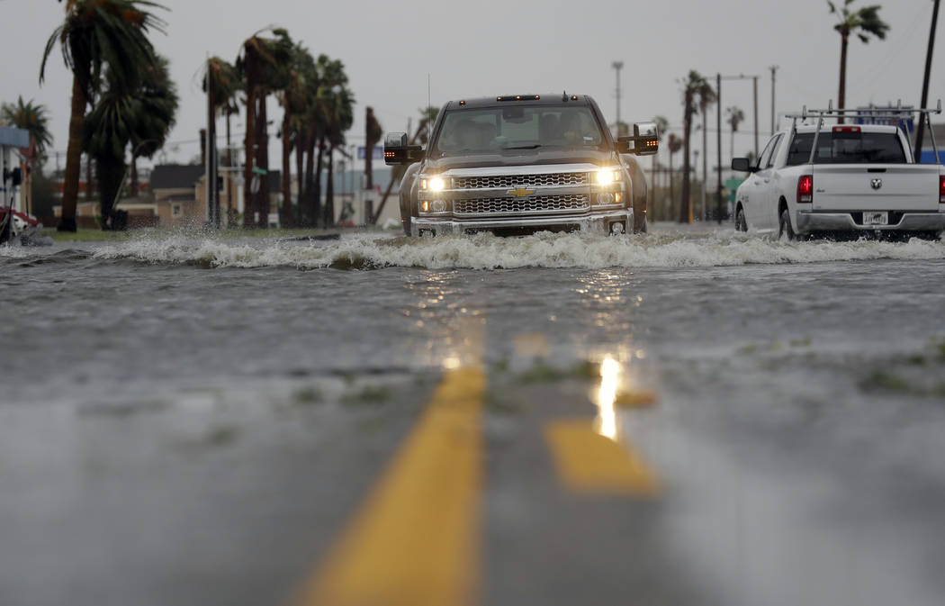 A drives moves through flood waters left behind by Hurricane Harvey, Saturday, Aug. 26, 2017, in Aransas Pass, Texas. Harvey rolled over the Texas Gulf Coast on Saturday, smashing homes and busi ...
