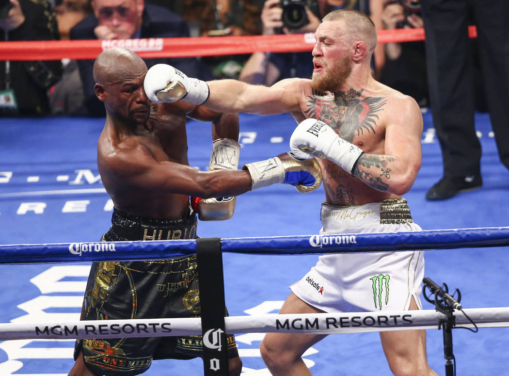 Floyd Mayweather Jr., left, fights Conor McGregor in their super welterweight fight at T-Mobile Arena, Saturday, Aug. 26, 2017, in Las Vegas. Mayweather won via 10th round technical knockout. Chas ...