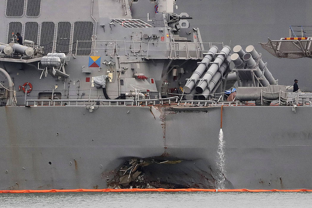 The damaged port aft hull of the USS John S. McCain is visible while docked at Singapore's Changi naval base in Singapore on Aug. 22.  (AP Photo/Wong Maye-E, File)