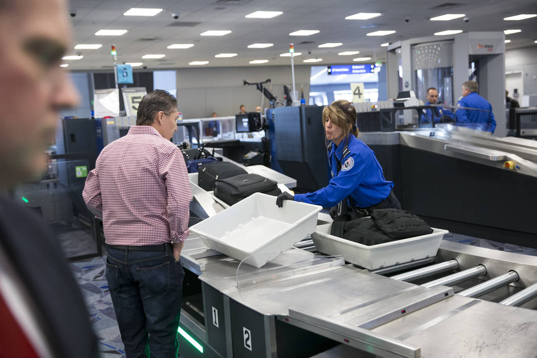 Transportation Security Administration agent Donna Franco, right, assists a passenger in one of the new automated screening lanes at McCarran International Airport Terminal 1 in Las Vegas, on Thur ...