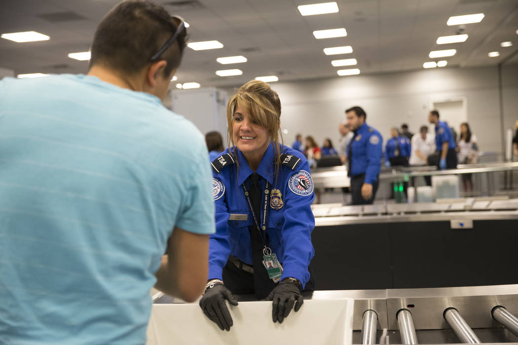 Transportation Security Administration agent Donna Franco assists a passenger in one of the new automated screening lanes at McCarran International Airport Terminal 1 in Las Vegas, on Thursday, Au ...