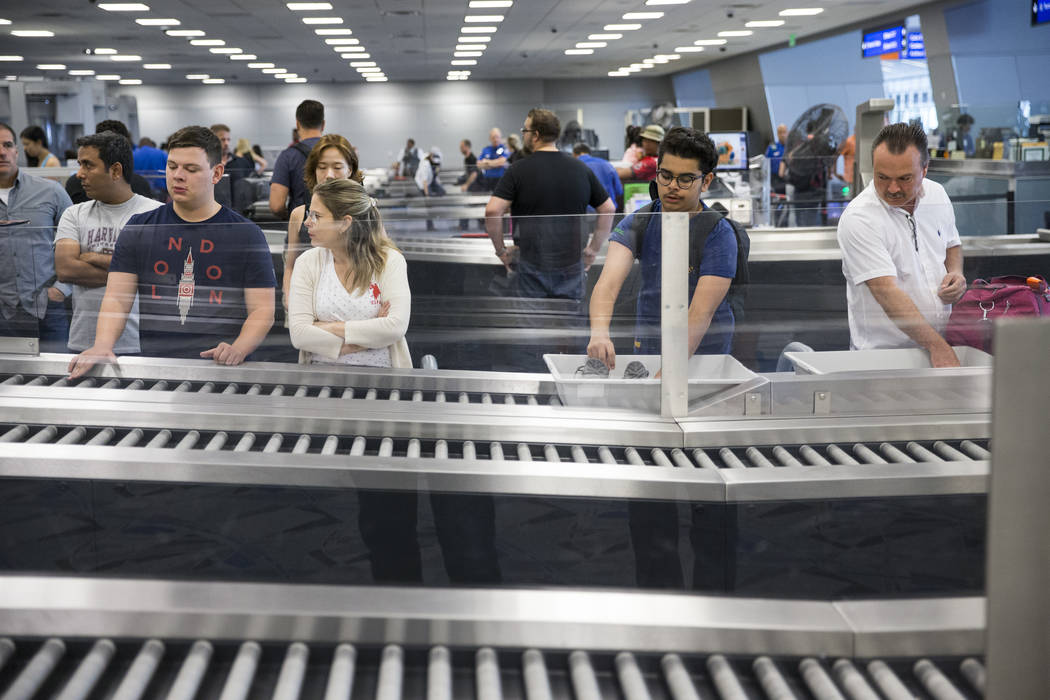 Passengers wait to retrieve their belonging from one of the new automated screening lanes at McCarran International Airport Terminal 1 in Las Vegas, on Thursday, Aug. 31, 2017. Erik Verduzco Las V ...