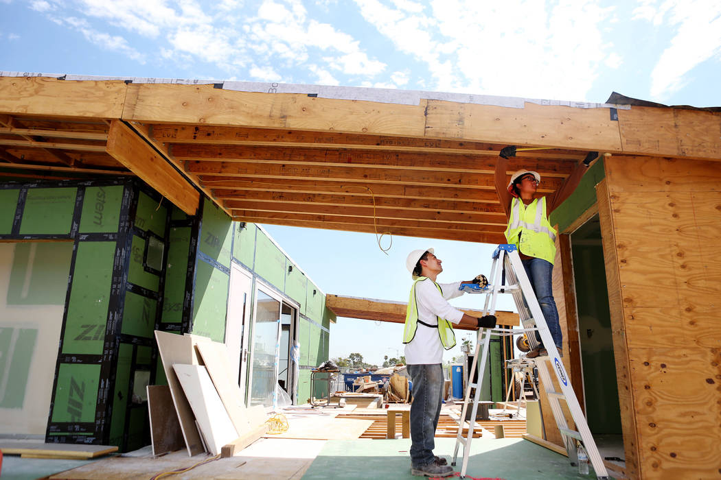 Architecture students Landon Baker, left, and Abbey Escala work on a solar-powered house which UNLV students design and build on UNLV's Paradise Campus in Las Vegas, Tuesday, Aug. 29, 2017. The UN ...