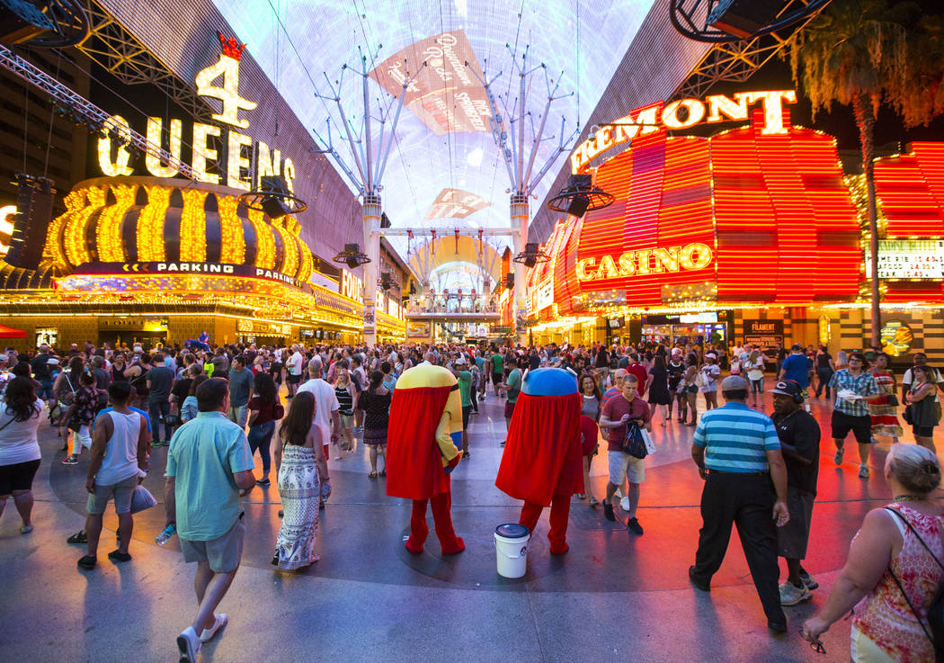 Buskers dressed as characters from &quot;Minions&quot; wait to pose with tourists for tips along the Fremont Street Experience in downtown Las Vegas on Wednesday, Aug. 2, 2017. Chase Steve ...