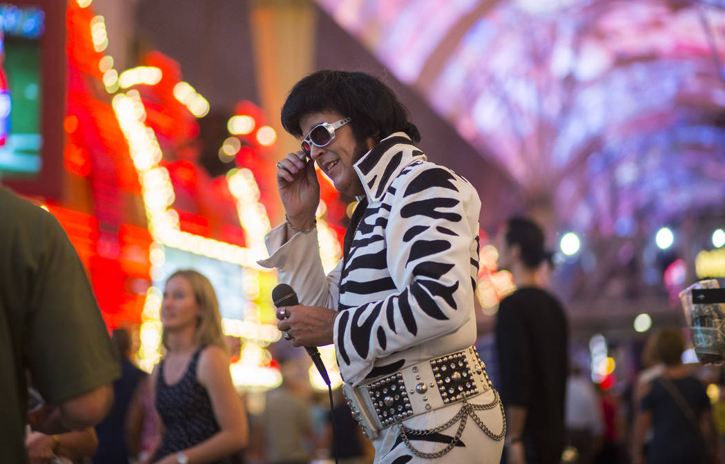 Chris Johnson, dressed as Elvis, is one of many costumed buskers offering photo opportunities along the Fremont Street Experience in downtown Las Vegas on Tuesday, Aug. 1, 2017. Chase Stevens Las  ...