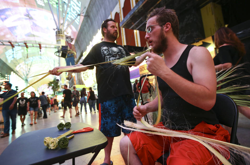 Roger, left, and Shaggy make items out of palm tree fronds along the Fremont Street Experience in downtown Las Vegas on Tuesday, Aug. 1, 2017. Chase Stevens Las Vegas Review-Journal @csstevensphoto