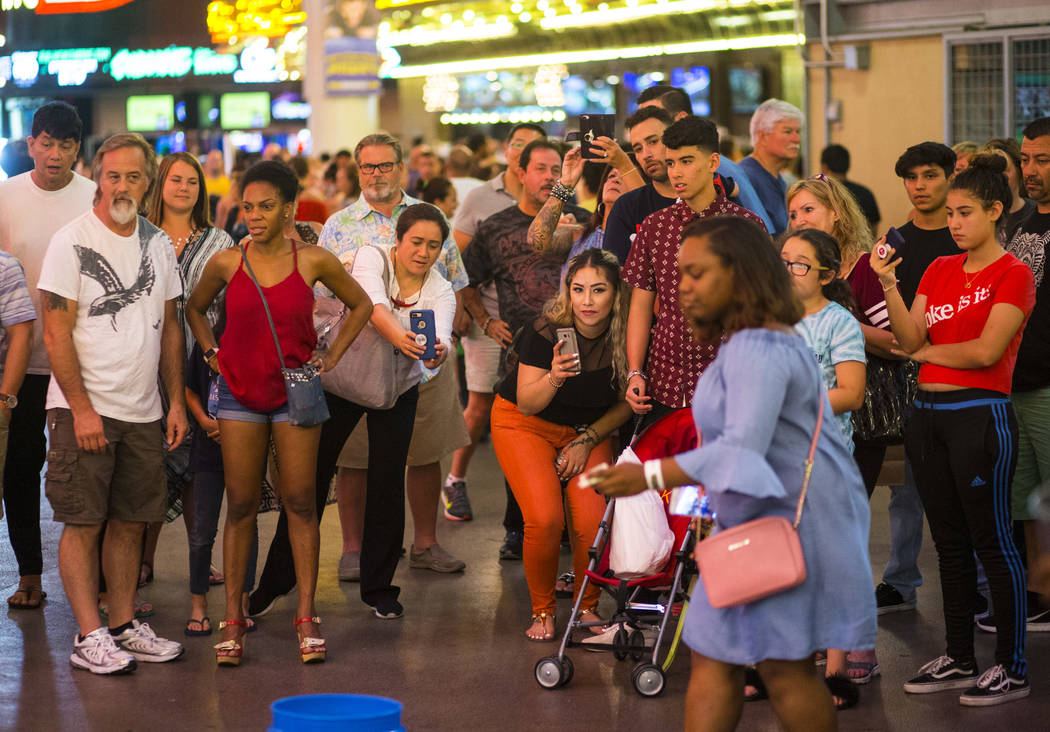 Tourists record and watch Bucket Nation, a group of buskers who drum on buckets, along the Fremont Street Experience in downtown Las Vegas on Thursday, Aug. 3, 2017. Chase Stevens Las Vegas Review ...