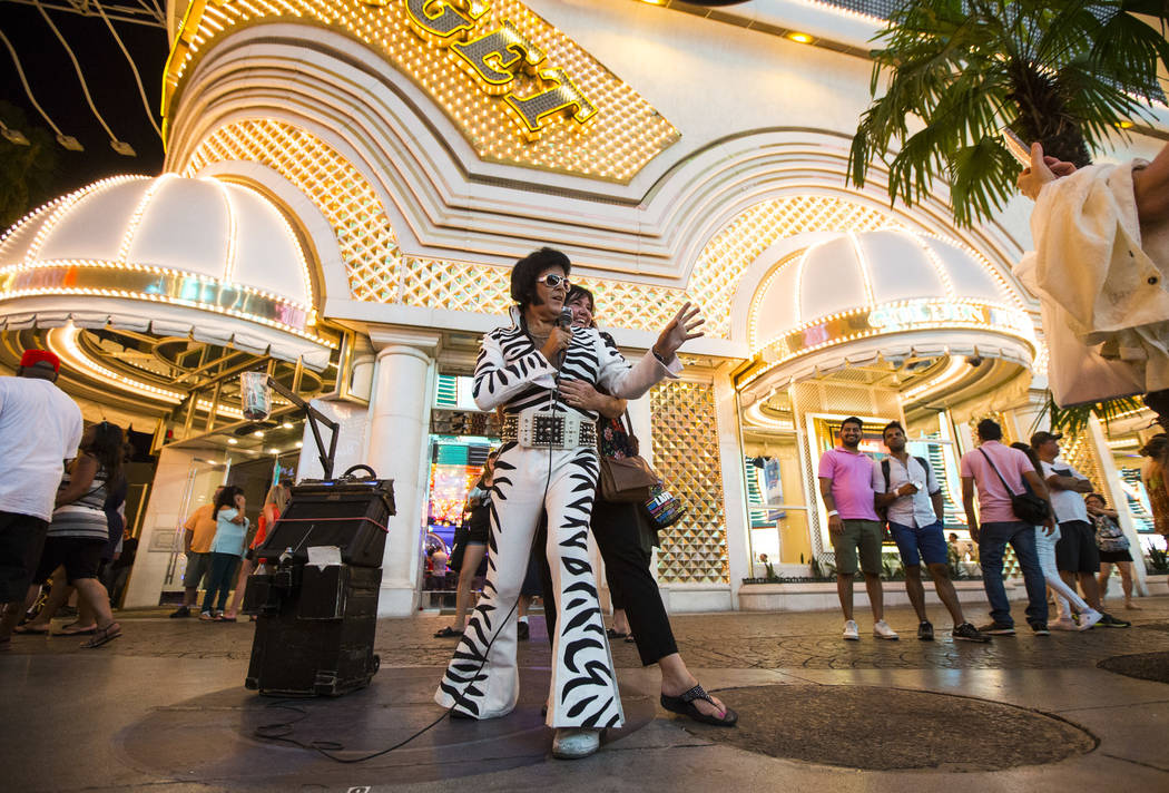 Chris Johnson, dressed as Elvis, poses for a photo with a tourist along the Fremont Street Experience in downtown Las Vegas on Tuesday, Aug. 1, 2017. Chase Stevens Las Vegas Review-Journal @csstev ...