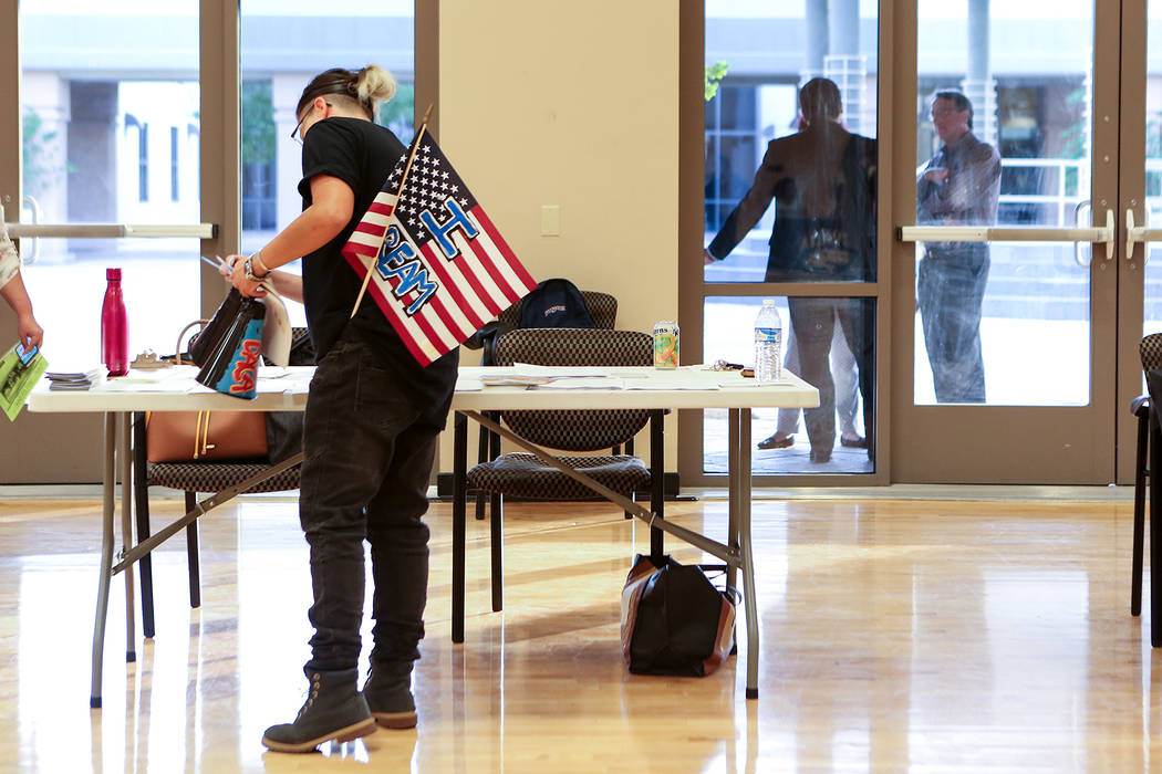 With an American flag that says &quot;I Dream&quot; sticking out of their pocket, an attendee picks up papers during an informative event on Deferred Action for Childhood Arrivals at East  ...