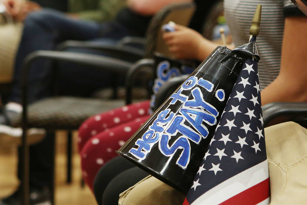 A megaphone that says "Here to stay!" taped on an American flag rests on an attendees's leg during an informative event on Deferred Action for Childhood Arrivals at East Las Vegas Community Center ...