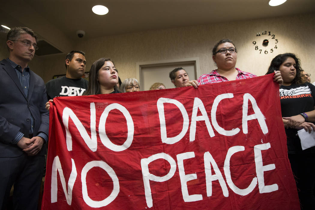 Dulce Valencia, left, organizer for the Progressive Leadership Alliance of Nevada, left, and, Victoria Osorio, recipient of the Deferred Action for Childhood Arrivals program, hold a banner while  ...