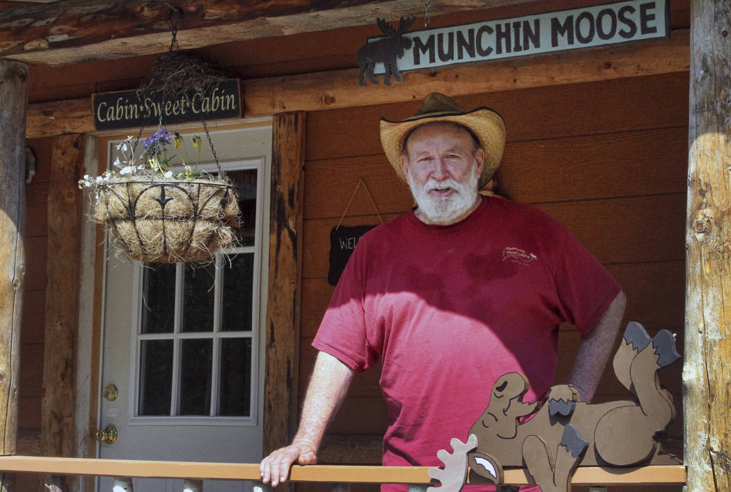 Owner Mike Stoltz poses for a photo in front of a cabin at his Meandering Moose Lodging in Talkeetna, Alaska, in July. (AP Photo/Mark Thiessen)