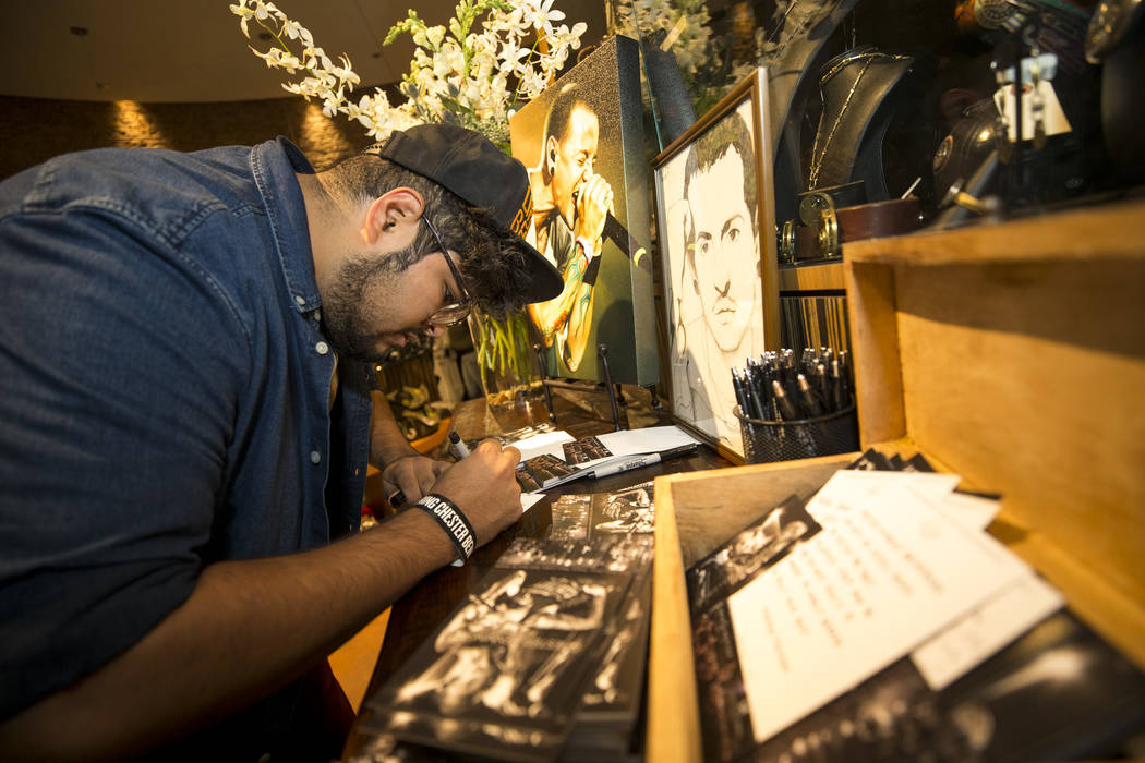 Linkin Park fan Charlie Vargas of Las Vegas leaves a note at a memorial for singer and songwriter Chester Bennington at Club Tattoo inside Planet Hollywood on Saturday, Sept. 2, 2017, in Las Vegas ...