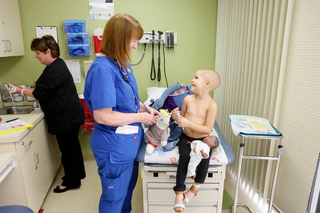 Sue Collins Waltermeyer, a child life specialist, center, talks with Leukemia patient Madilyn Cash, 4, while Nurse Practitioner Arlene Bayreder working at the Children's Specialty Center of Nevada ...
