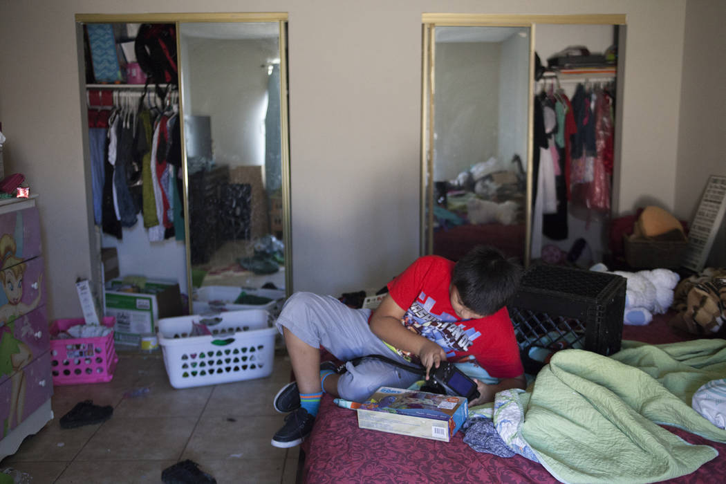 Ivan Meneses plays with his camera at his home in Las Vegas, Thursday, Aug. 10, 2017. Meneses' mother fears that a change in current health care laws will take away access to Medicaid for herself  ...