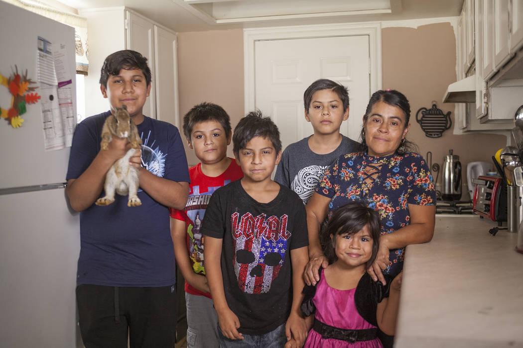 Jacob Meneses, 13, holding Brownie II, from left, his siblings Angel Meneses, 9, Ivan Meneses, 10, Emanuel Meneses, 12, Ruby Estrada, 4, and their mother Ivon Meneses in their kitchen in Las Vegas ...