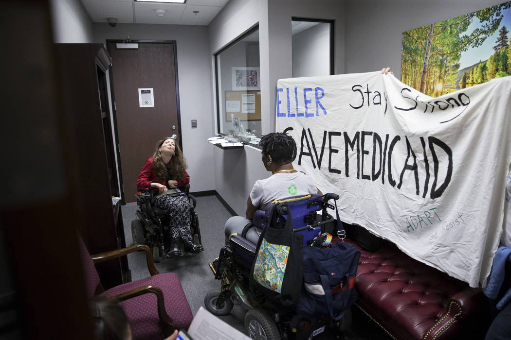 Sascha Bittner, left, and Monique Harris, demonstrate in support of the Medicaid program inside the office of Sen. Dean Heller, R-Nev., in Las Vegas, on Thursday, July 20, 2017. Erik Verduzco Las  ...