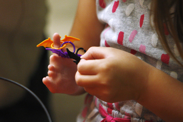 Hailey Dawson stings Halloween rings on her "special hand" while waiting for adjustments to be made to her new prosthetic hand Thursday, Oct. 30, 2014 at UNLV. (Sam Morris/Las Ve ...