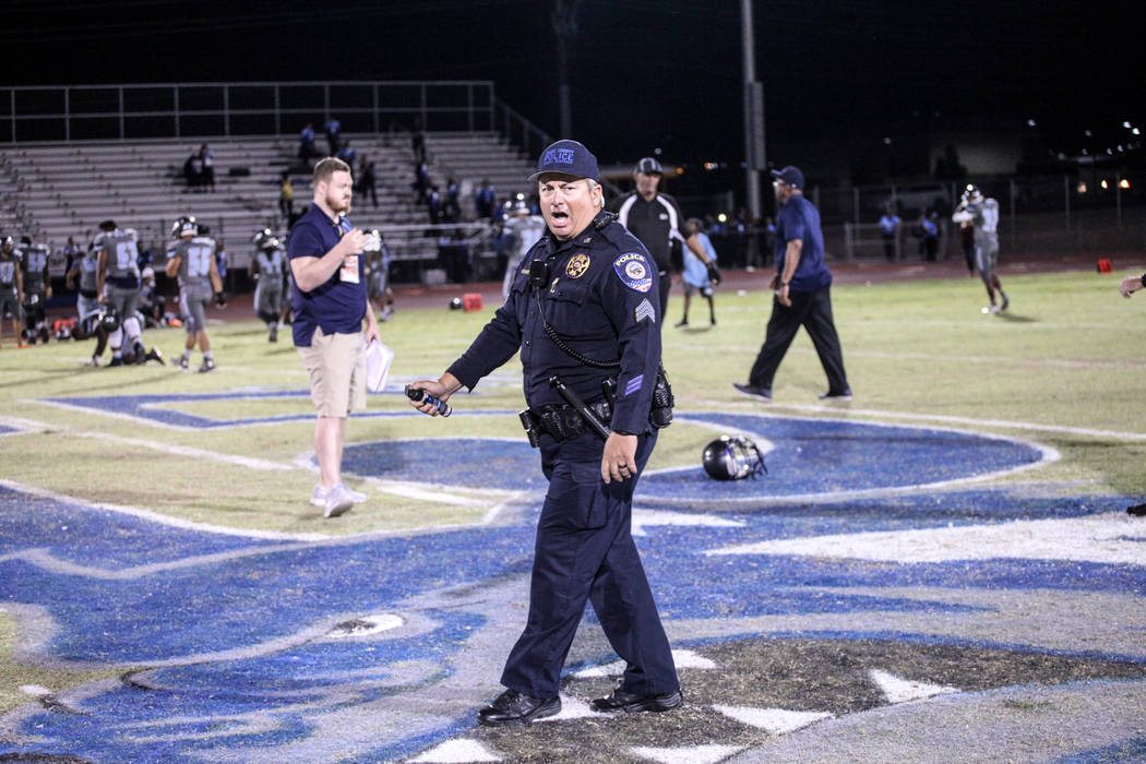 A police officer holds pepper spray after dispersing a brawl between Canyon Springs and Basic Academy's football teams at the end of a game at Basic High School in Henderson, Friday, Sept. 15, 201 ...