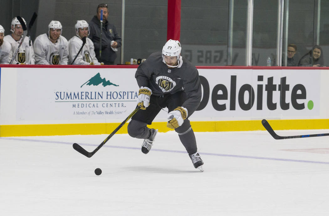 Vegas Golden Knights left defenseman Shea Theodore (27) attempts to gain control of the puck in a scrimmage game during the NHL team's practice at the City National Arena in Las Vegas, Saturday, S ...