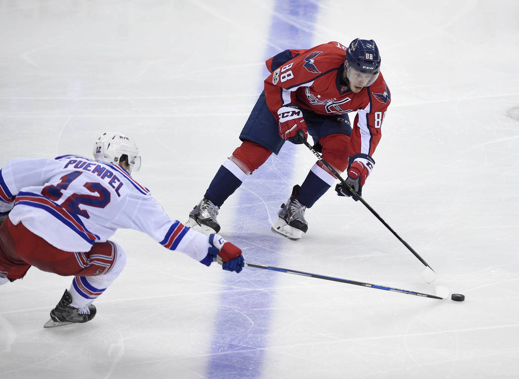 Washington Capitals defenseman Nate Schmidt (88) battles for the puck against New York Rangers left wing Matt Puempel (12) during the third period of an NHL hockey game, Wednesday, April 5, 2017, ...