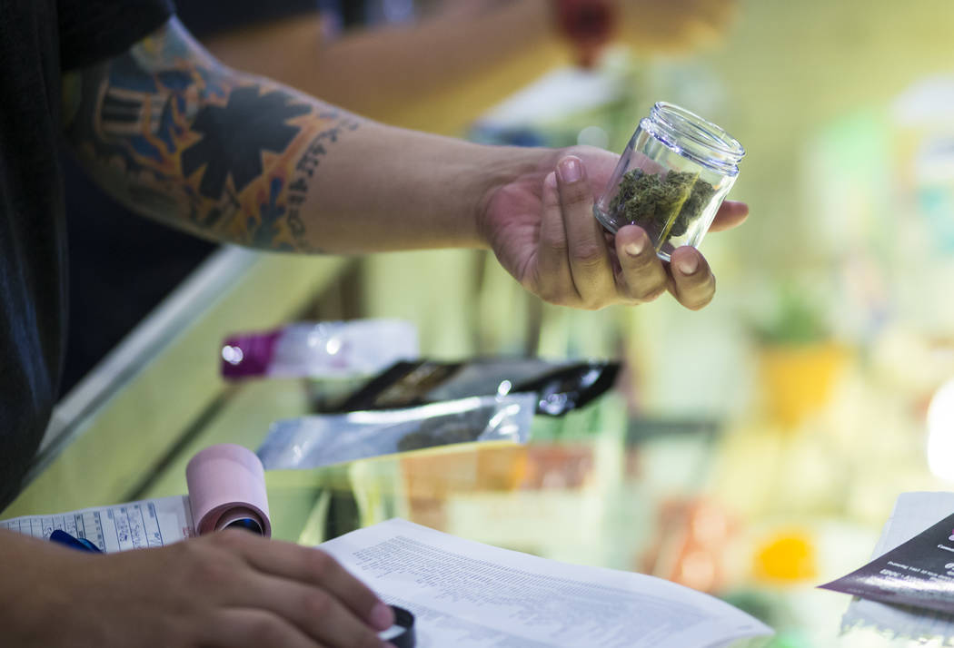 Budtender Tom Nieves displays marijuana products to customers during the first day of recreational sales at Acres Cannabis in Las Vegas on Saturday, July 1, 2017. Chase Stevens Las Vegas Review-Jo ...