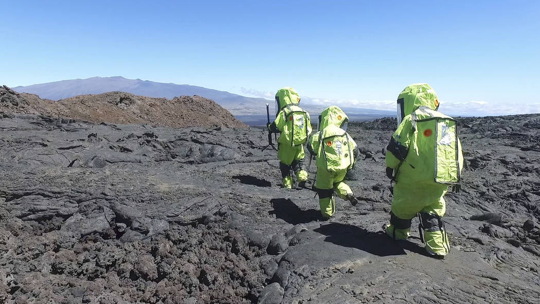 In this 2017 photo released by the University of Hawaii crew members of Mission V, walk across lava next to the university’s facility Hawaii Space Exploration Analog and Simulation (HI-SEAS) at  ...