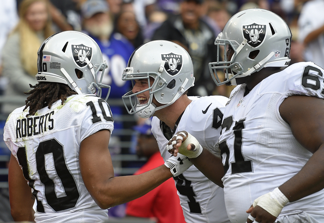 Oakland Raiders wide receiver Seth Roberts, left, celebrates his touchdown with quarterback Derek Carr, center, and center Rodney Hudson in the first half of an NFL football game against the Balti ...
