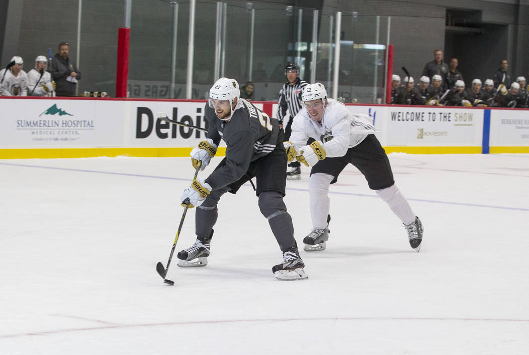 Vegas Golden Knights left defenseman Shea Theodore, left, (27) breaks away from Golden Knights defenseman Dmitry Osipov (79) in a scrimmage game during the NHL team's practice at the City National ...