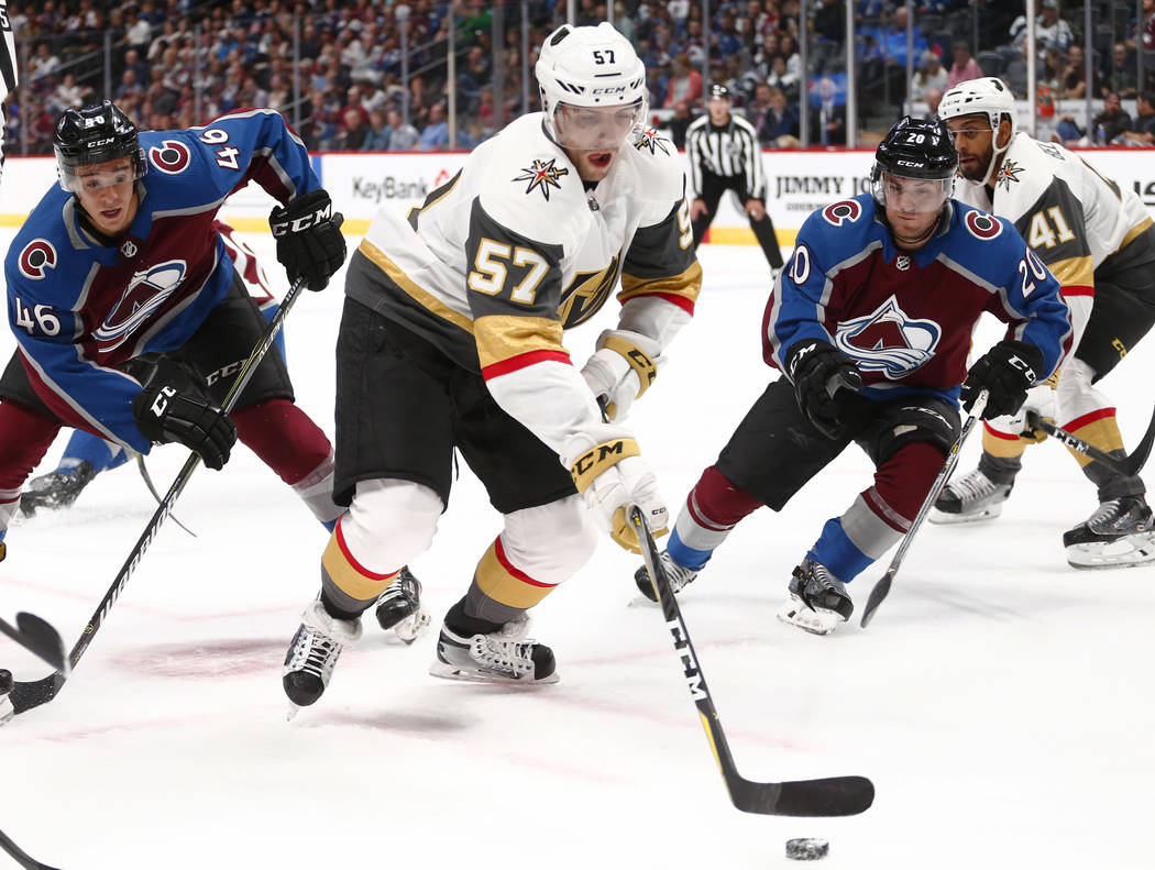 Las Vegas Golden Knights left wing David Perron (57) moves the puck away from Colorado Avalanche center J.C Beaudin (46) and Rocco Grimaldi (20) during the first period of a preseason hockey game, ...