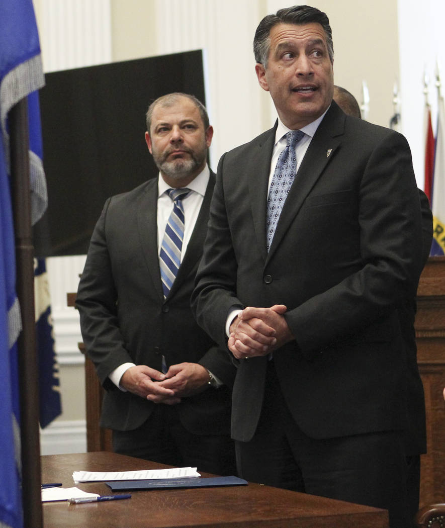 Gov. Brian Sandoval, center, speaks before signing a group of bills while flanked by Assembly Minority Floor Leader Paul Anderson, R-Las Vegas, left, and Senate Majority Leader Aaron Ford, D-Las V ...
