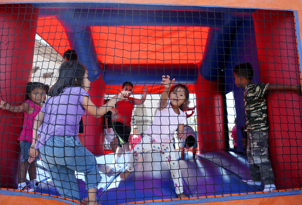 Kids play in a jump house during a Marianaճ Charity Foundation benefit for earthquake victims in Mexico supported by the Latin Chamber of Commerce at Mariana's Supermarket on West Sahara Ave ...
