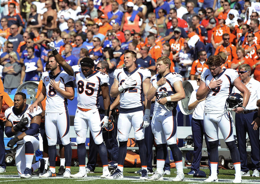 Denver Broncos tight end Virgil Green (85) gestures as teammate Max Garcia, left, takes a knee during the playing of the national anthem prior to an NFL football game against the Buffalo Bills, Su ...