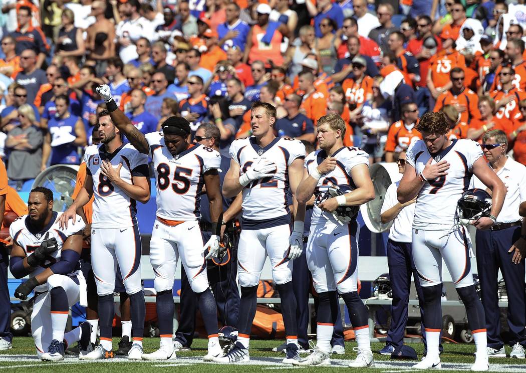 Denver Broncos tight end Virgil Green (85) gestures as teammate Max Garcia, left, takes a knee during the playing of the national anthem prior to an NFL football game against the Buffalo Bills, Su ...