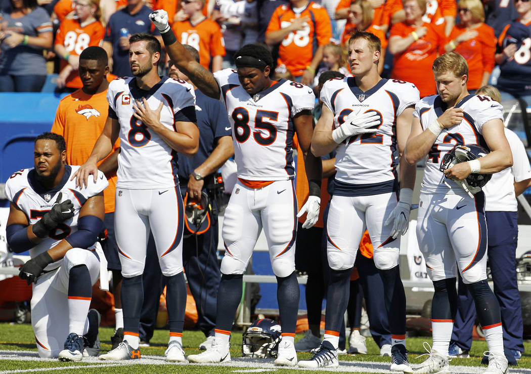 Denver Broncos tight end Virgil Green (85) gestures and offensive guard Max Garcia, left, kneels during the playing of the national anthem prior to an NFL football game against the Buffalo Bills,  ...