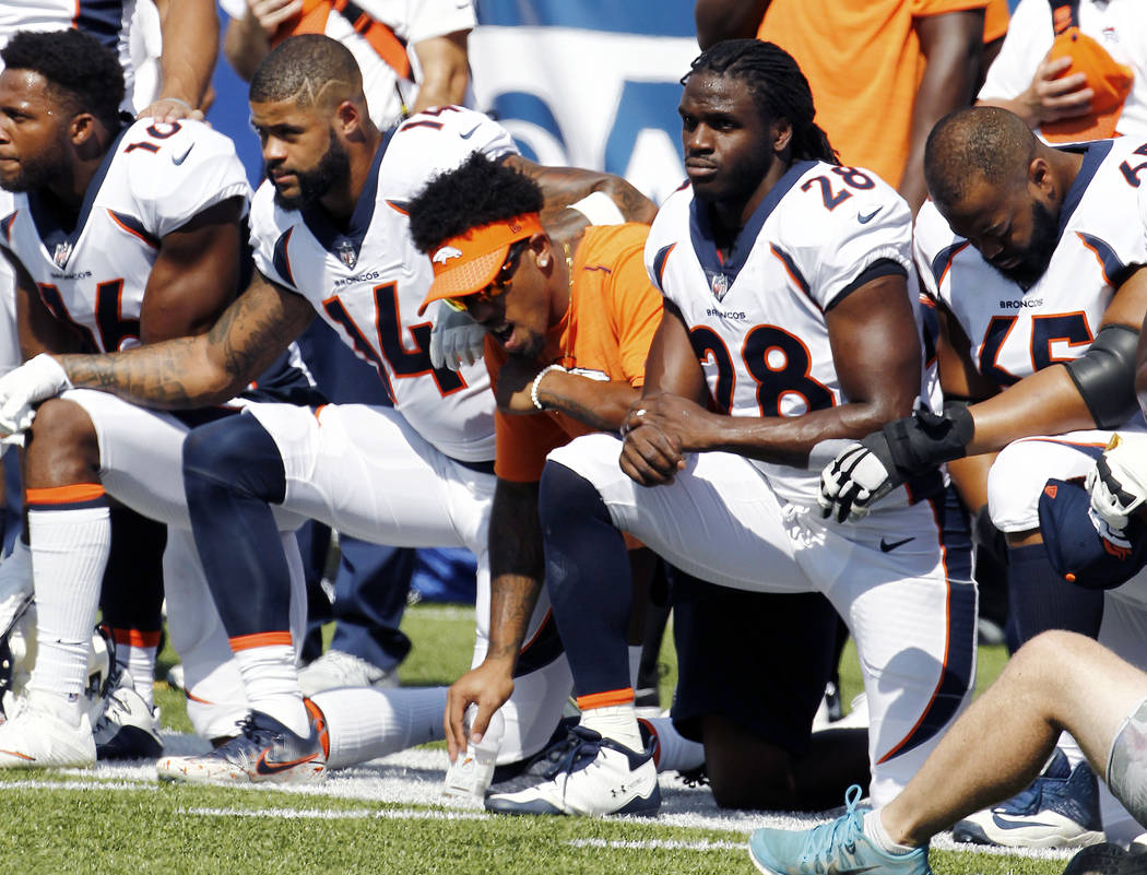 Denver Broncos players, including Jamaal Charles (28) kneel during the national anthem prior to an NFL football game against the Buffalo Bills, Sunday, Sept. 24, 2017, in Orchard Park, N.Y. (AP Ph ...