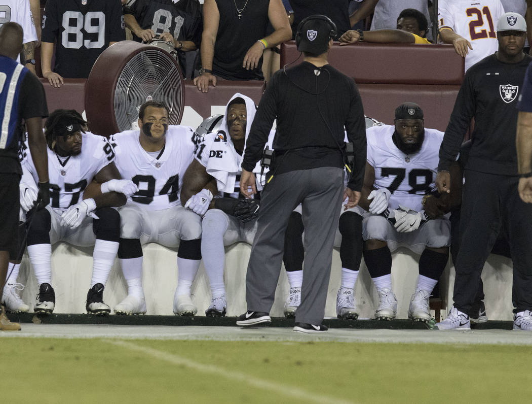 Some of the Oakland Raiders interlock arms and sit during the national anthem before their game against the Washington Redskins in Landover, Md., Sunday, Sept. 24, 2017. Heidi Fang Las Vegas Revie ...