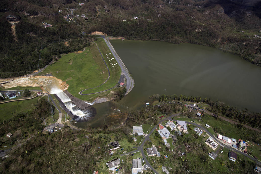 Water drains from the Guajataca Dam in Quebradillas, Puerto Rico, Saturday, Sept. 23, 2017. Puerto Rican officials rushed to evacuate tens of thousands of people downstream of the failing dam and  ...