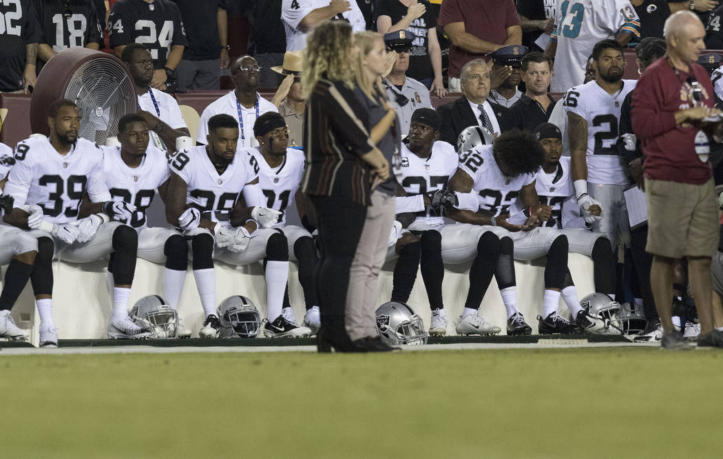 Some of the Oakland Raiders interlock arms and sit during the national anthem before their game against the Washington Redskins in Landover, Md., Sunday, Sept. 24, 2017. Heidi Fang Las Vegas Revie ...
