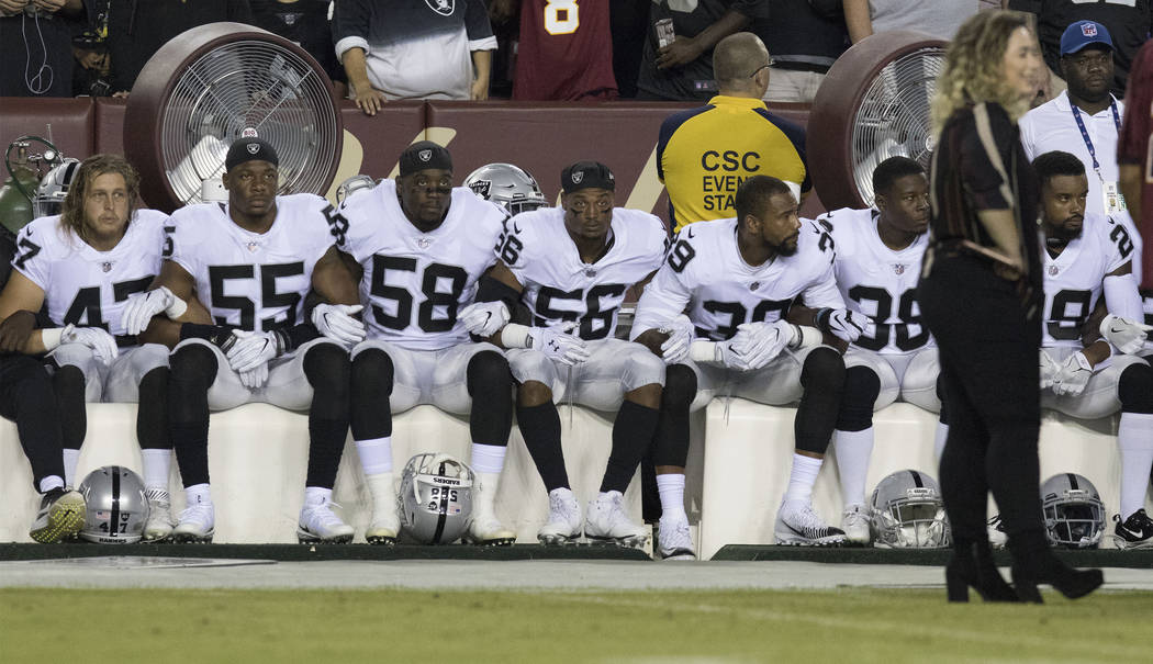The Oakland Raiders interlock arms and sit during the national anthem before their game against the Washington Redskins in Landover, Md., Sunday, Sept. 24, 2017. Heidi Fang Las Vegas Review-Journa ...