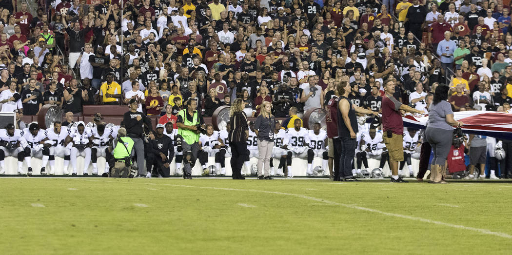 The Oakland Raiders interlock arms and sit during the national anthem before their game against the Washington Redskins in Landover, Md., Sunday, Sept. 24, 2017. Heidi Fang Las Vegas Review-Journa ...