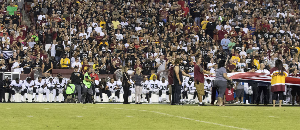 The Oakland Raiders interlock arms and sit during the national anthem before their game against the Washington Redskins in Landover, Md., Sunday, Sept. 24, 2017. Heidi Fang Las Vegas Review-Journa ...