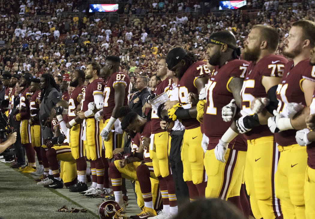 The Washington Redskins interlock arms during the national anthem before their game against the Oakland Raiders in Landover, Md., Sunday, Sept. 24, 2017. Heidi Fang Las Vegas Review-Journal @HeidiFang