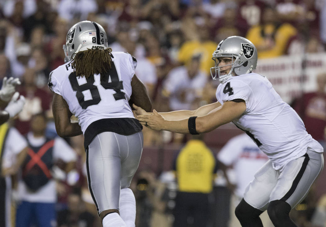 Oakland Raiders quarterback Derek Carr (4) hands off the football to wide receiver Cordarrelle Patterson (84) in the first half of their game against the Washington Redskins in Landover, Md., Sund ...
