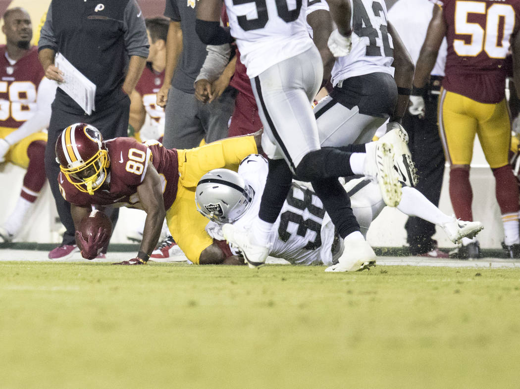 Washington Redskins wide receiver Jamison Crowder (80) is tackled by Oakland Raiders cornerback T.J. Carrie (38) after a catch in the second half of their game at the FedEx Field in Landover, Md., ...